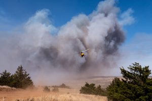A helicopter flying over the Rhea Wildfire